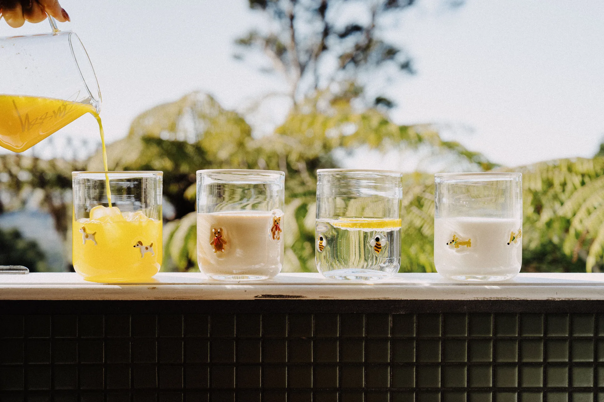 Ada Studio character glasses filled with drinks and arranged with fresh lemons